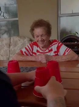 Una persona mayor realiza una actividad recreativa acompañada.