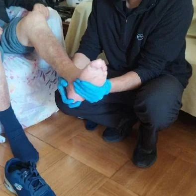 Una cuidadora ayuda a una persona mayor durante una actividad de movilidad.